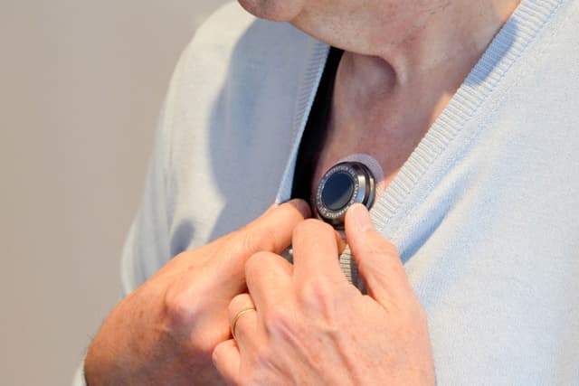 Photo of someone wearing the CUE1+ device on their chest.