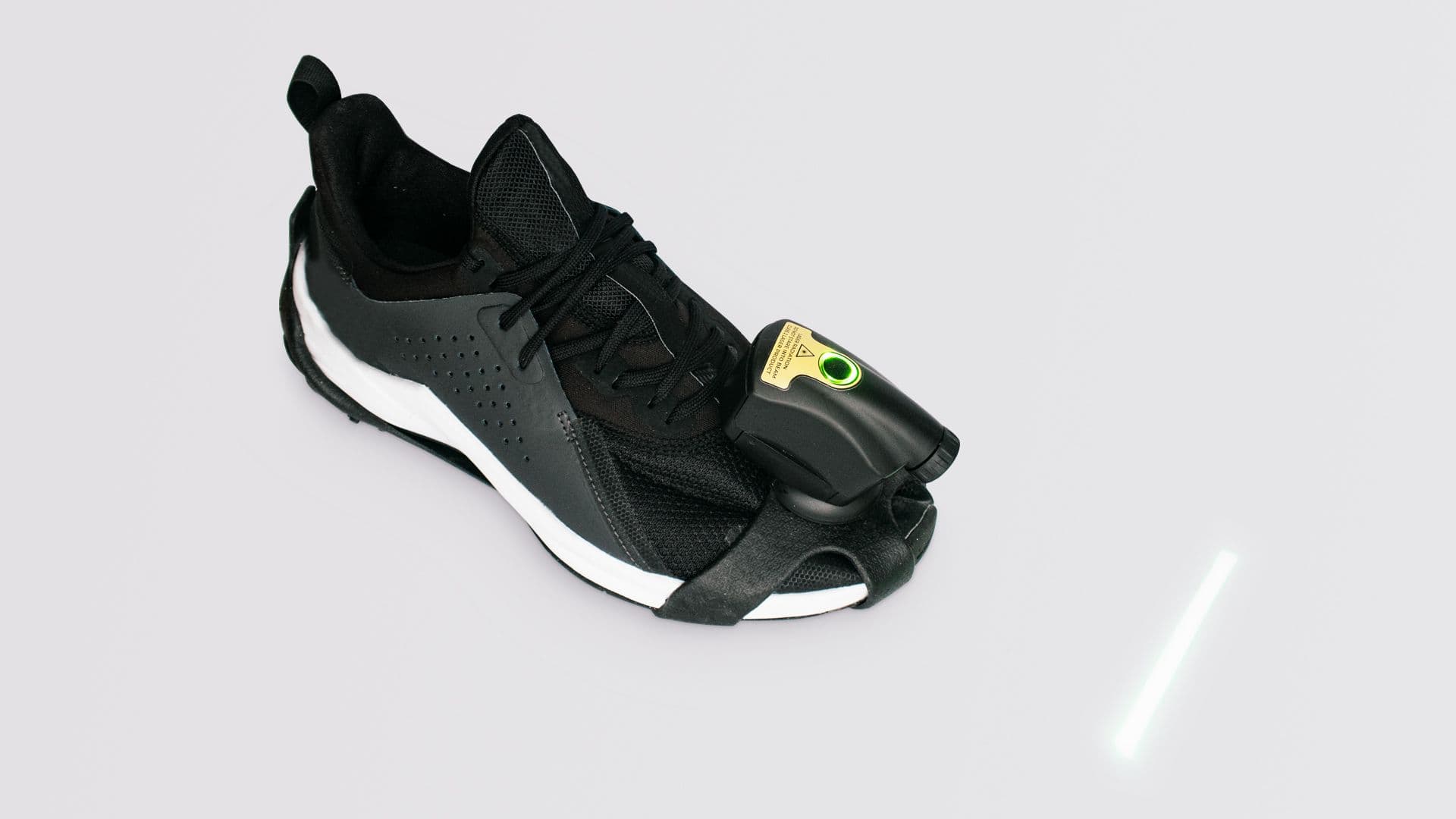 A photo of one black trainer with the Path Finder strapped on to it.