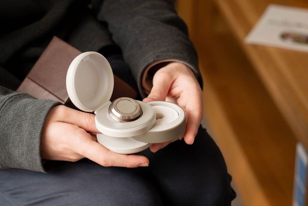 Photo of someone holding the CUE1+ in its carry case in the stone colour option.