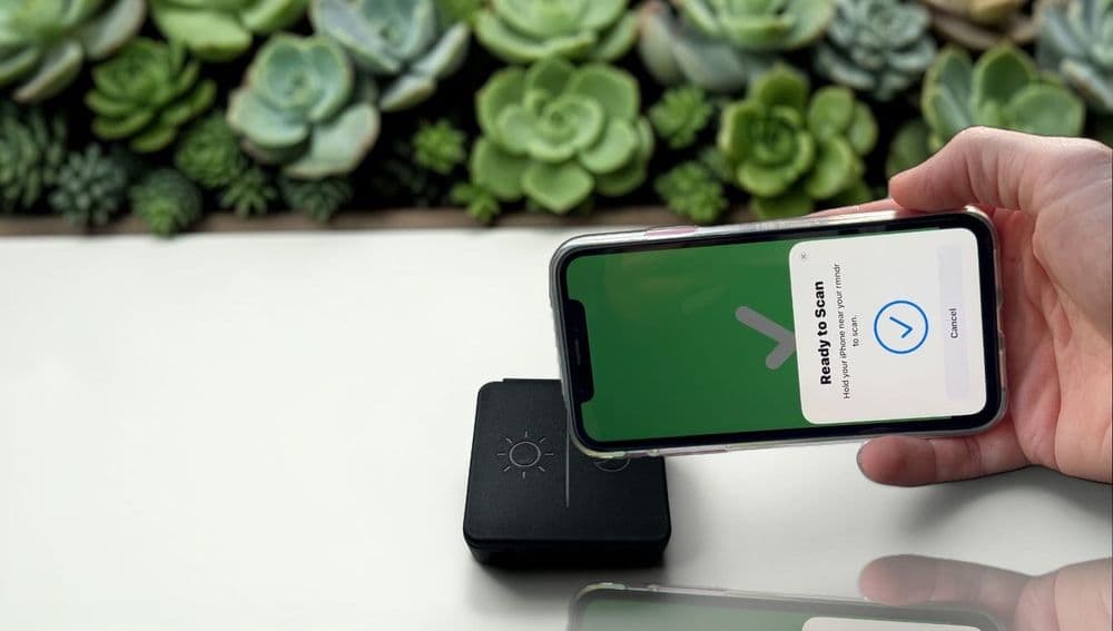 Photo of an iPhone being tapped against a pill pot to log a dose.