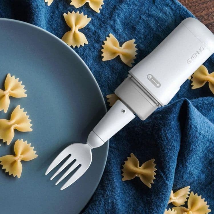 The Bravo Twist with the fork attachment pictured on a blue plate surrounded by pasta.