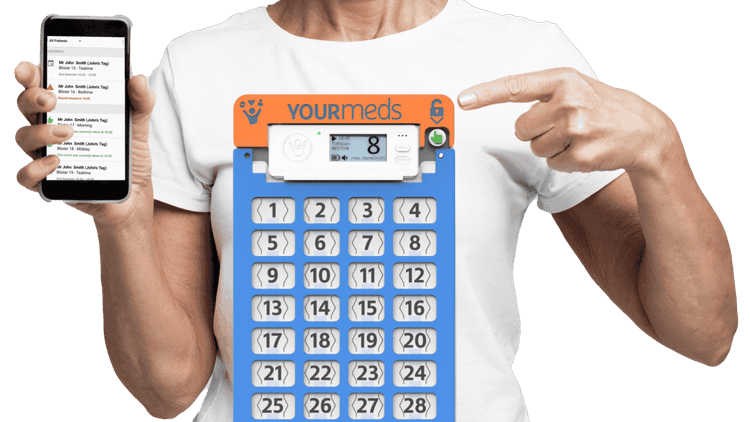 A woman's hand pointing at a YourMEDS box in front of her. In her other hand, she is holding a smartphone with the YourMEDS app open.