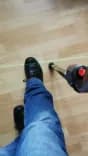 A close-up photo of the LaserCane's green laser besides someone's shoe.