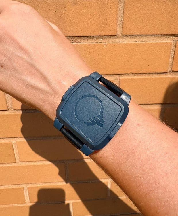 A photo of the BeechBand 100E on a person's wrist. The wearable is dark blue and engraved with the BeechBand logo.