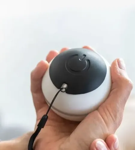 A Vilim Ball being held in one hand, supported by a second hand, with a white background.