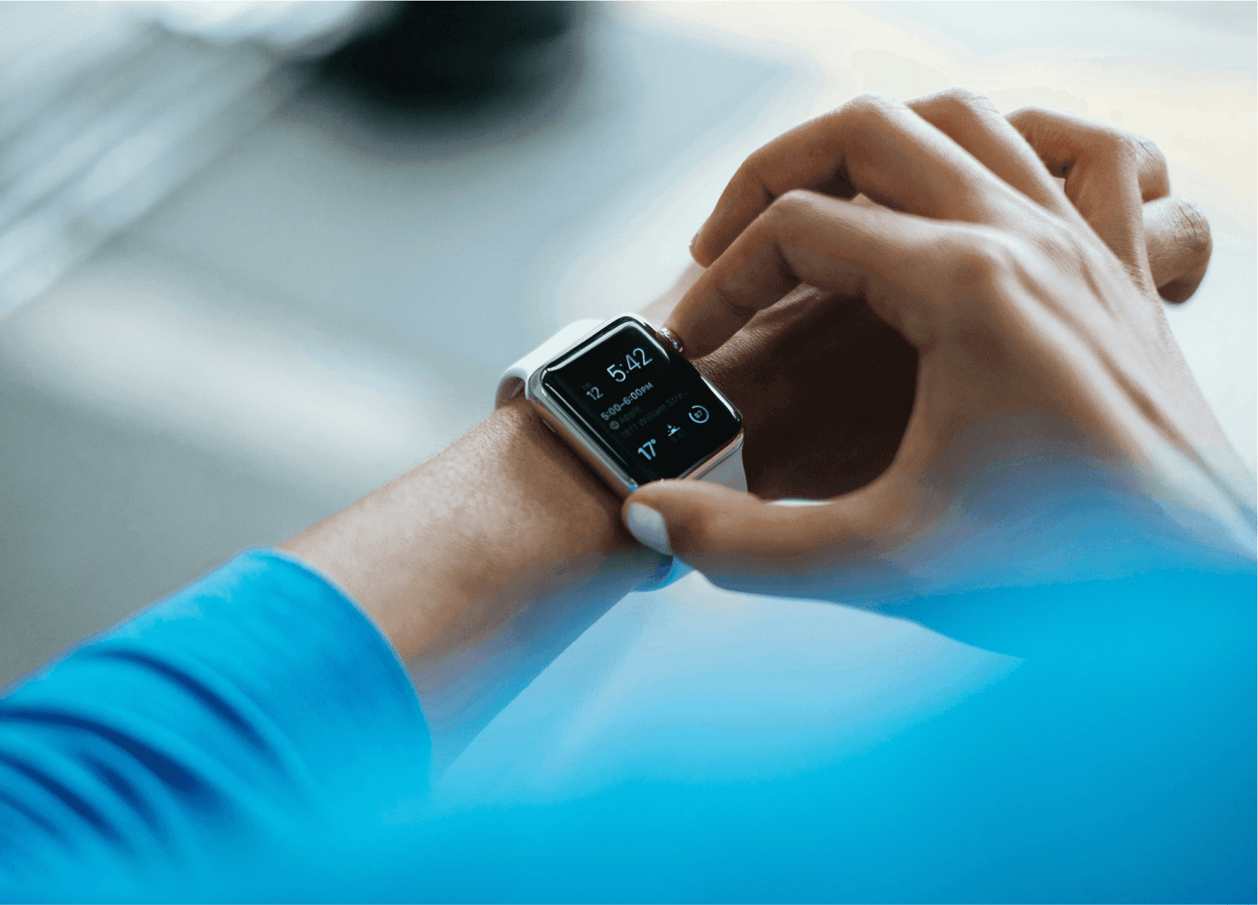 A photo of a smartwatch on someone's wrist. The person is turning the dial with their other hand.